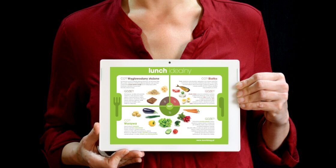 Kobieta trzymająca w ręku tablet, na tablecie wyświetlona infografika Lunch idealny.