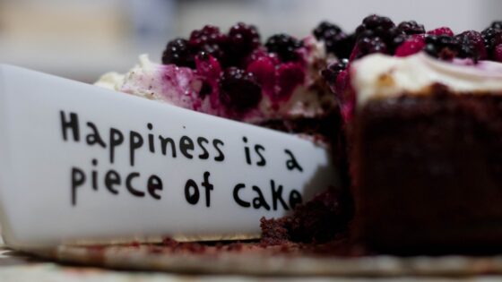 Tort owocowy z wbitym napisem "Hapiness is a piece of cake" - szczęście to kawałek ciasta!