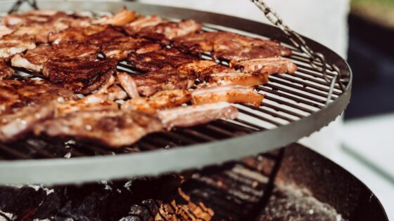 Na zdjęciu zbliżenie na grill. Na grillu leży boczek. Dieta ketogeniczna (ketogenna)