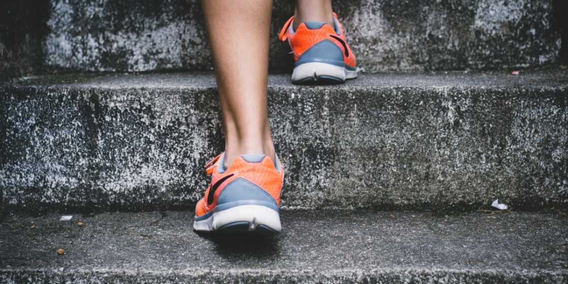 Zbliżenia na buty treningowe na stopach kobiety. Korzyści z aktywności fizycznej, treningu.